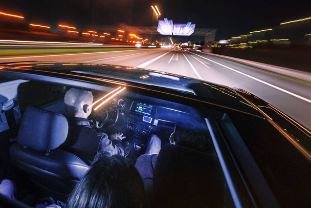 couple of friends in a luxury car driving at night - Photo, image