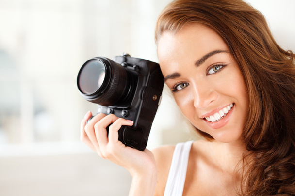 Pretty woman is a proffessional photographer with dslr camera - Фото, изображение