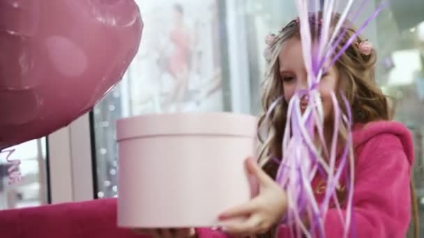 Little girl giving present box with baloons to two pretty girls. close up - Footage, Video
