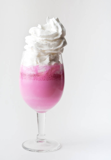 Bebida rosa con crema batida en vidrio, fondo blanco aislado
 - Foto, imagen