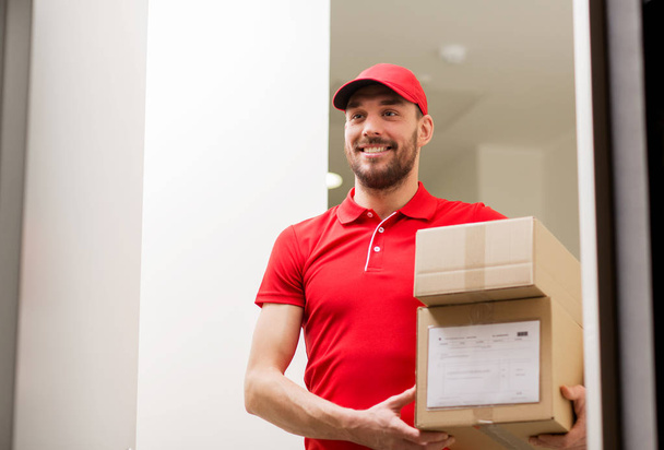 delivery man with parcel boxes at customer door - Фото, изображение