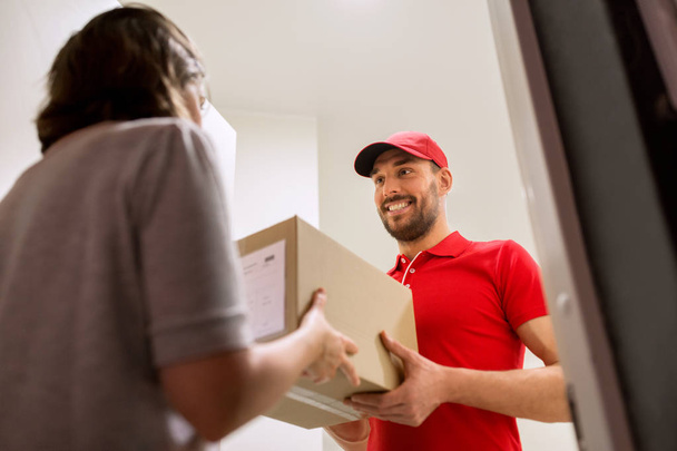 happy delivery man giving parcel box to customer - 写真・画像