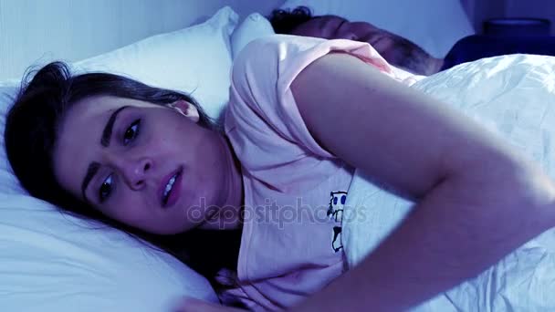 Woman cheating on sleeping husband chatting with lover on cell phone at night - Imágenes, Vídeo