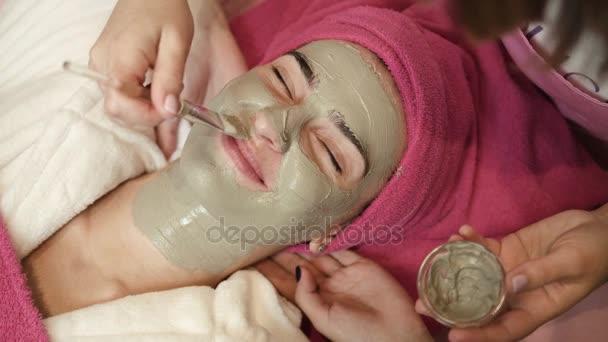 Master profesjonalne zastosowanie gliny na twarzy womans w salonie spa. Procedura z masażem twarzy w gabinecie kosmetycznym. Pielęgnacja twarzy. Leczenia. Z bliska - Materiał filmowy, wideo