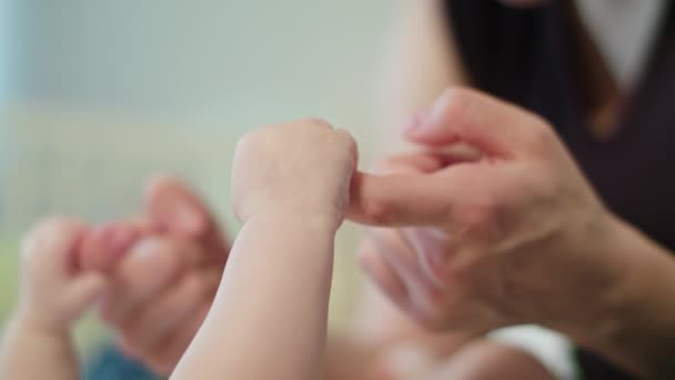 Babys pequeña mano está sosteniendo madres dedo
 - Imágenes, Vídeo