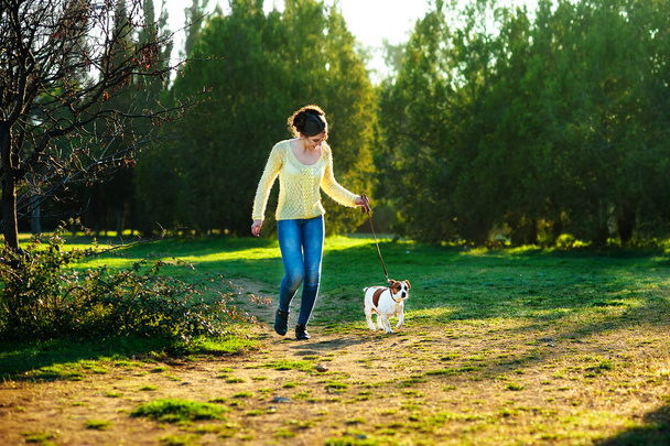 Happy young woman jogging with her Jack Russell terrier dog - Foto, afbeelding