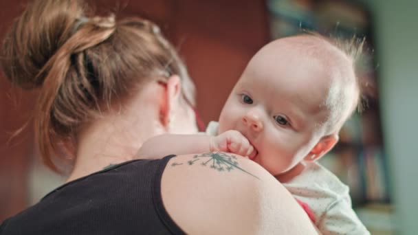 Roztomilé dítě matka rameni pěstí v ústech - Záběry, video