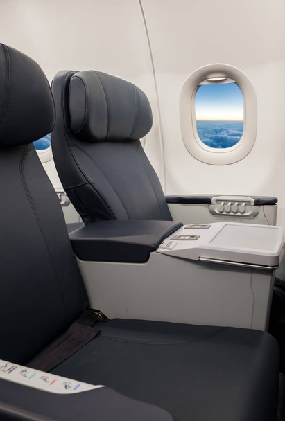 Asientos vacíos y ventana dentro de una aeronave
 - Foto, Imagen