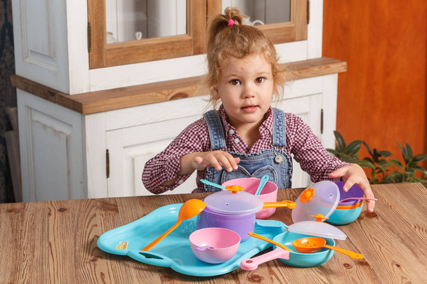 小さな女の子が遊んで自宅グッズ ベビー用食器 - 写真・画像