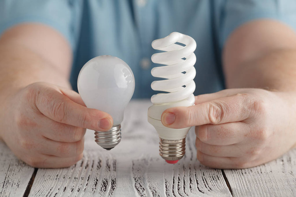 Man hold Normal and Saver Lightbulb - Foto, Imagen
