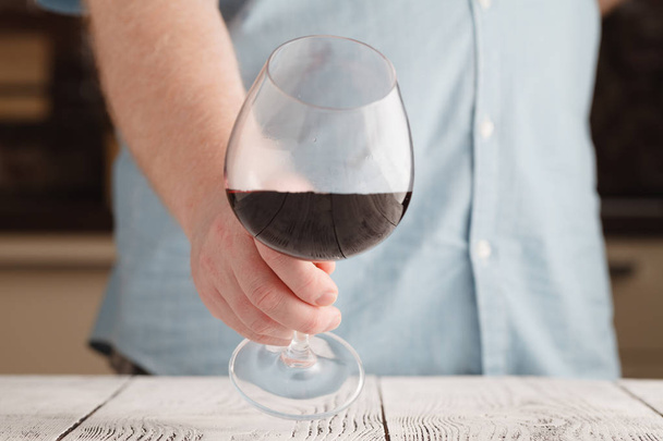 Man sniffing red wine in a glass, close up - Фото, изображение