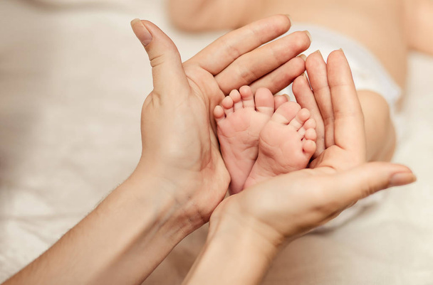 Madre sosteniendo diminuto pie del bebé recién nacido
 - Foto, imagen