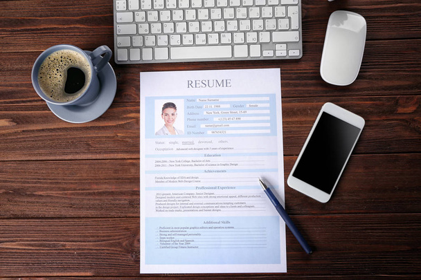 Resume, phone and keyboard on wooden table - Photo, Image