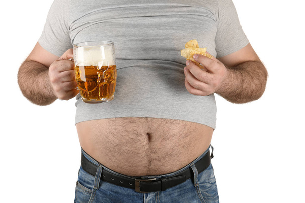 Man with big belly holding glass of beer and snack  - Photo, image