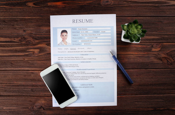 Resume and phone on wooden table - Φωτογραφία, εικόνα
