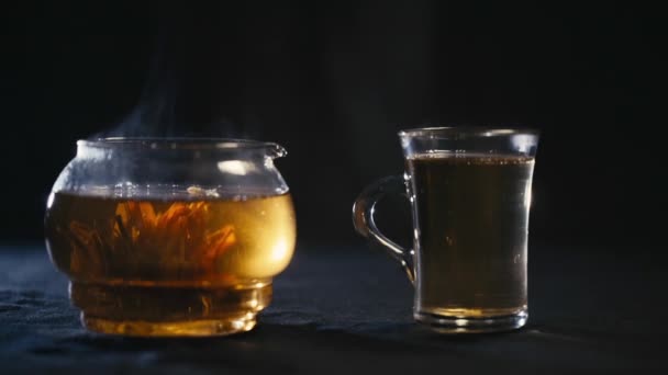 Chinese green tea Bud blooms in a glass teapot. A Cup of tea - Filmati, video