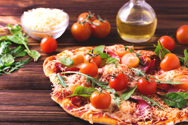 Домашняя пицца с беконом, помидорами, шпинатом, рукколой и сыром
 - Фото, изображение