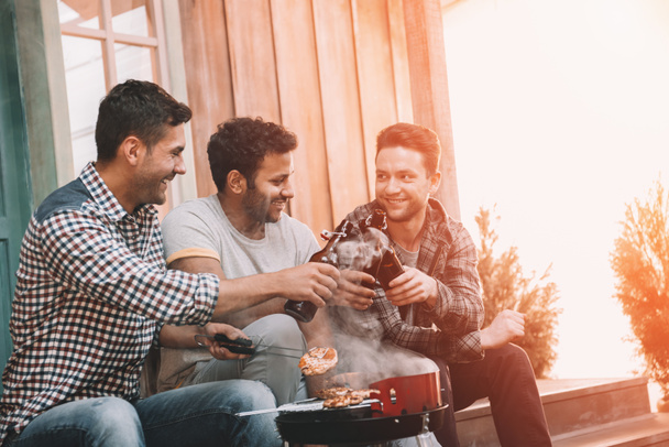 Friends drinking beer and making barbecue  - Photo, Image
