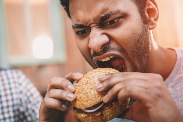 Hombre comiendo hamburguesa
  - Foto, Imagen