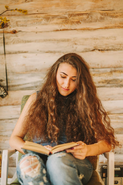 Πορτρέτο του ένα κορίτσι με μακριά, σγουρά, φυσικά μαλλιά. κορίτσι ανάγνωση  - Φωτογραφία, εικόνα