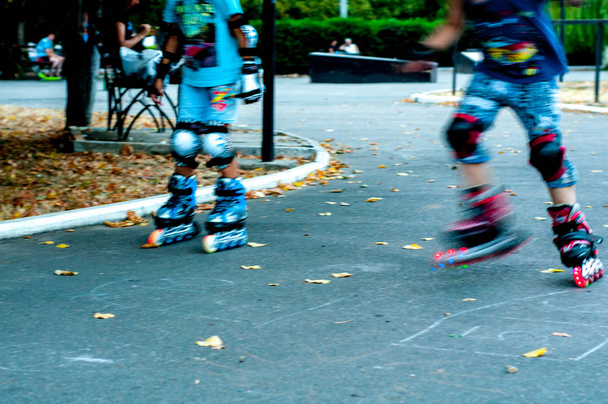 Patinaje infantil sobre patines en el parque
 - Foto, Imagen