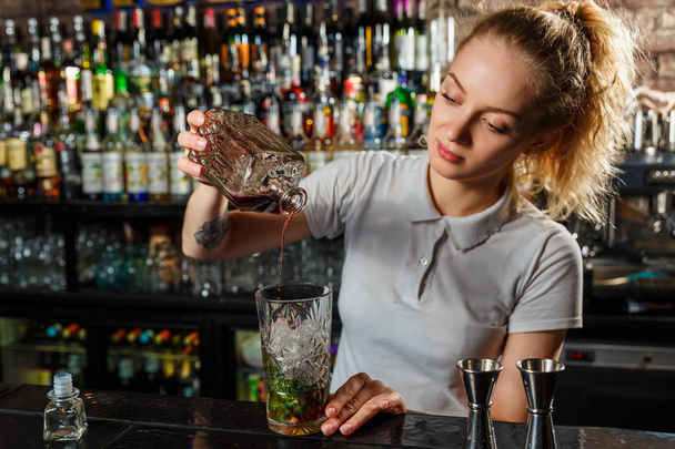 Woman bartender making an alcohol cocktail - Foto, Imagem