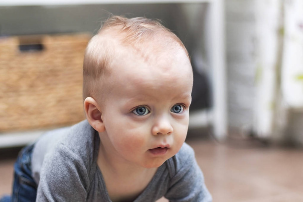 深刻な 1 歳幼児ポートレート、クローズ アップ。彼の考えの美しい青い目を持つ魅力的な悲しい金髪少年 - 写真・画像