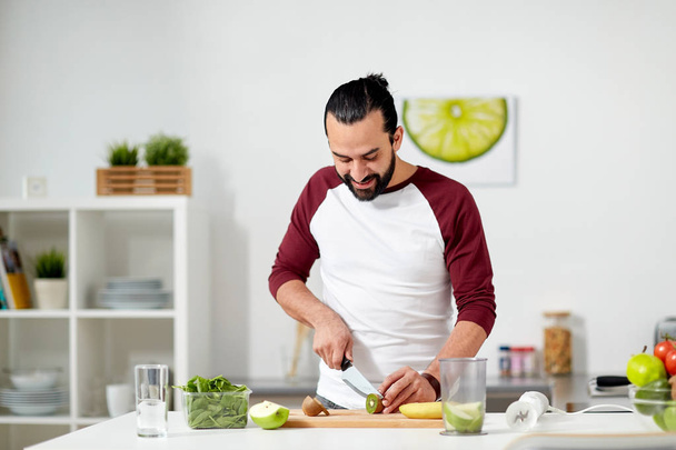 man with blender and fruit cooking at home kitchen - Fotoğraf, Görsel