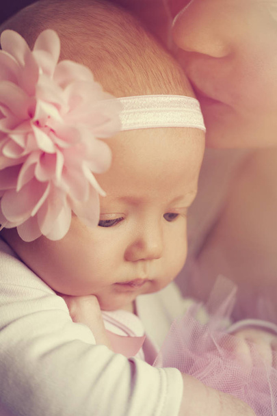 Bonito menina bonita com bela fita rosa com sua mãe
 - Foto, Imagem