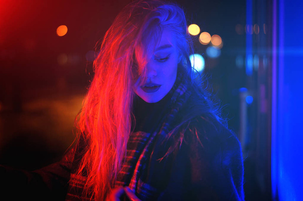 Sexy young woman posing over night city dramatic neon background - Valokuva, kuva