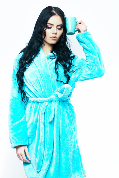 sexy girl posing in turquoise velour bathrobe with cup - 写真・画像