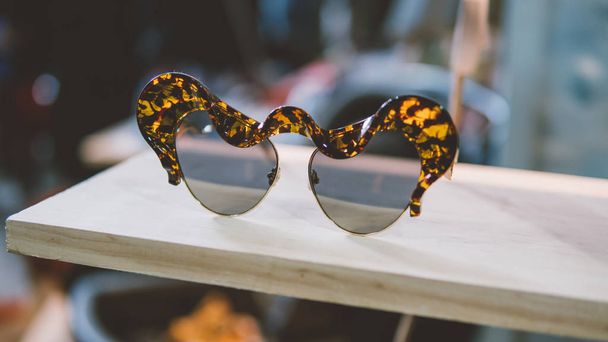 occhiali da sole vintage su un ripiano in legno. Occhiali e abbigliamento vintage moda. Occhiali da hipster e moda. Concentrazione superficiale
  - Foto, immagini