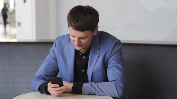 young man texting on a mobile device - Filmati, video