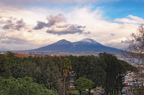 Kaunis näkymä kaupungin Napoli (Napoli) ja vuori Vesuvius taustalla pilvisenä talvipäivänä. Campania, Italia
 - Valokuva, kuva