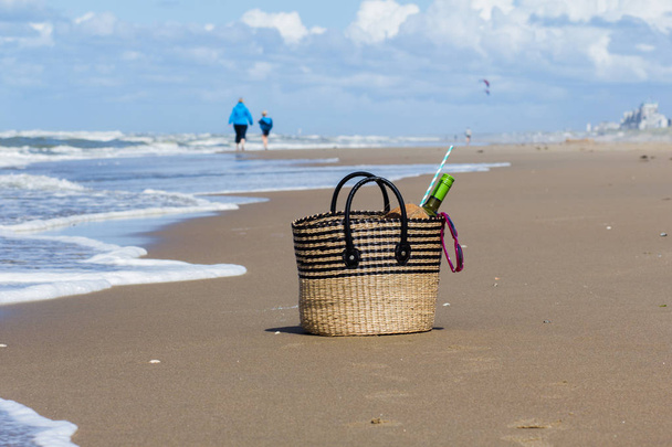 Mother and son on the beach  in the distance and picnic basket - Photo, Image