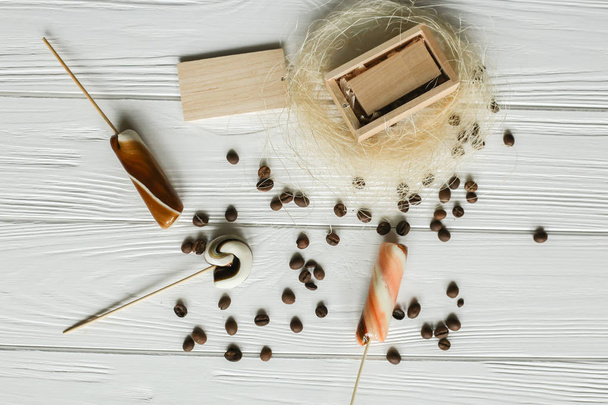 Set of coffee beans and chocolate sweets. White wooden background. Space for text  - Photo, Image