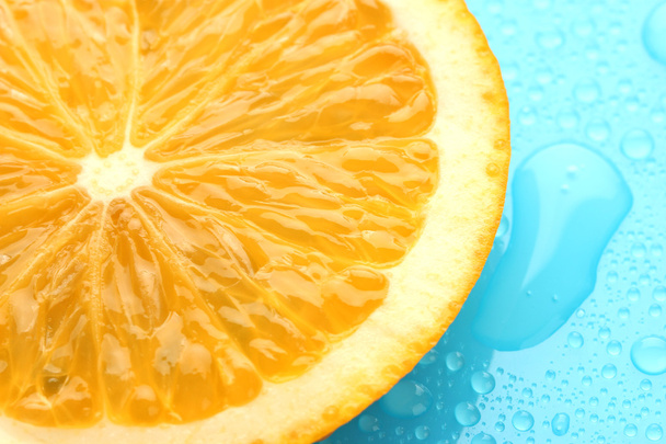 Slice of lime with drop on blue background - Foto, Imagem