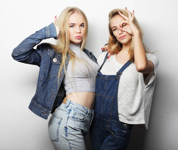Two young girl friends standing together and having fun - Foto, imagen