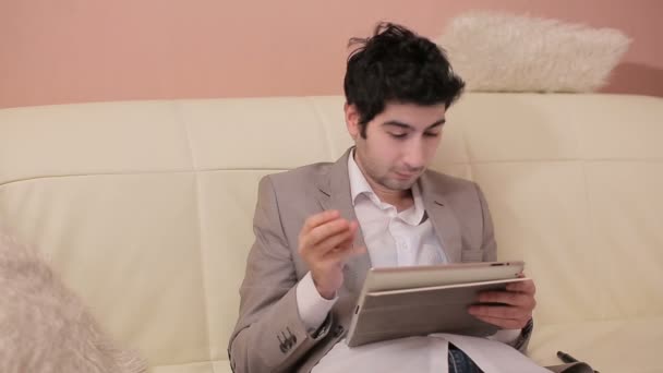 Emotional young businessman working with tablet. - Materiał filmowy, wideo