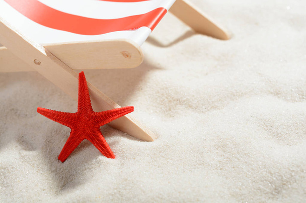 Estrella de mar roja cerca de una tumbona en la playa
 - Foto, imagen