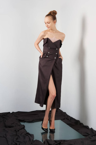 Fashion model in cocktail dress with buttons and without shoulder straps - Φωτογραφία, εικόνα