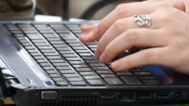 Female hands typing on the keyboard of a laptop in shopping mall - Footage, Video
