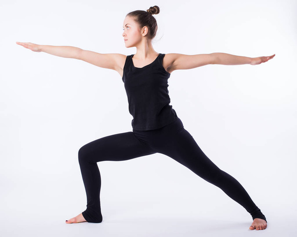Jeune femme de yoga pose guerrière. Cela fait partie d'une série de différentes poses de yoga par ce modèle, isolé sur blanc
 - Photo, image