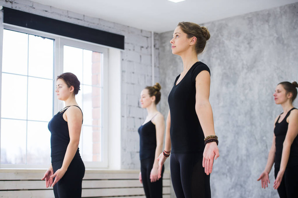 Women doing yoga sun salutation pose indoors at yoga studio - Zdjęcie, obraz