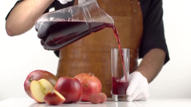 Man pours juice in a jar on table with fruits - Materiał filmowy, wideo