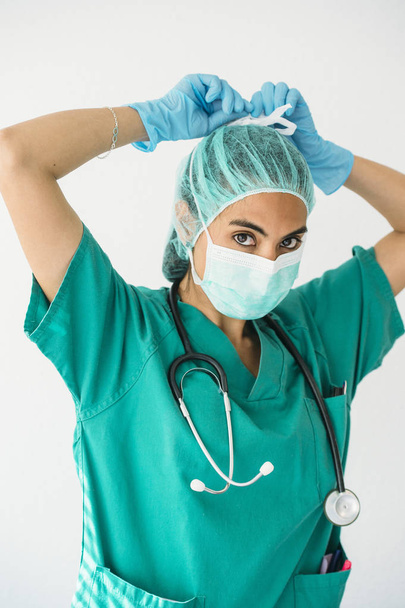 Female nurse tying surgical mask  - Фото, зображення