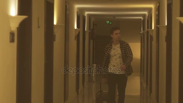 Νεαρός άνδρας τράβηγμα βαλίτσα στο ξενοδοχείο - Πλάνα, βίντεο