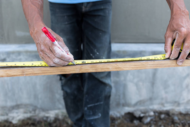 Ruban à mesurer main charpentier avec stylo rouge
 - Photo, image