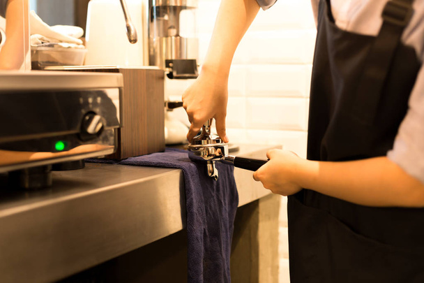 Barista presses ground coffee using tamper  - Foto, Imagen