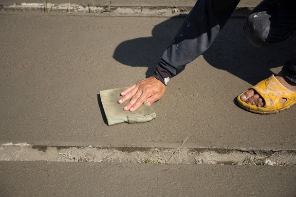 Worker smooth concrete floor with sponge  - Photo, Image
